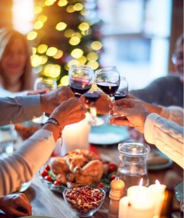 gedekte tafel, 4 persnonen die met een glas wijn klinken