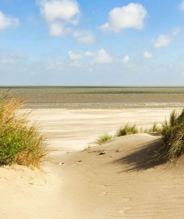 foto van de zee getrokken tussen twee zandduinen door